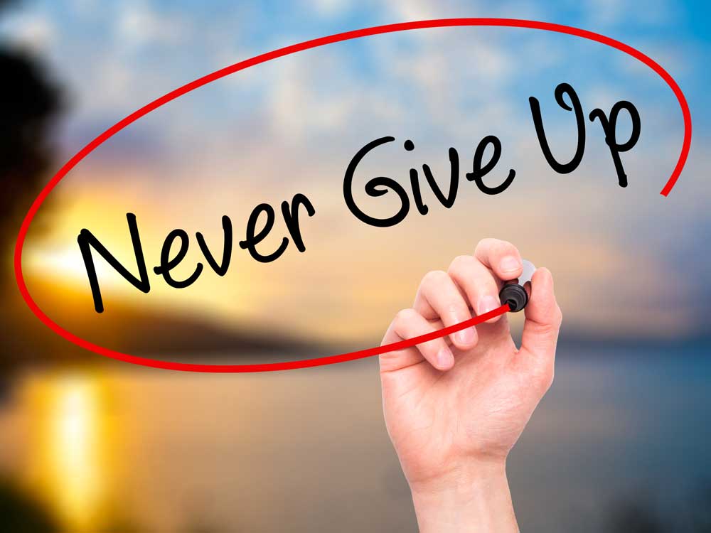 יד רושמת על רקע נוף של ים: "never give up"